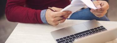 Man Checking Tax Receipts at Laptop