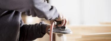 handyman at work sanding wearing goggles