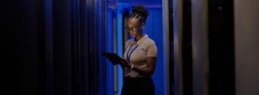 image showing business woman holding laptop in dark room