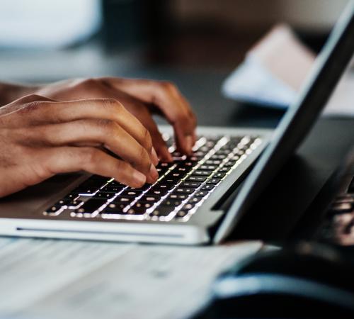 A person typing on a laptop