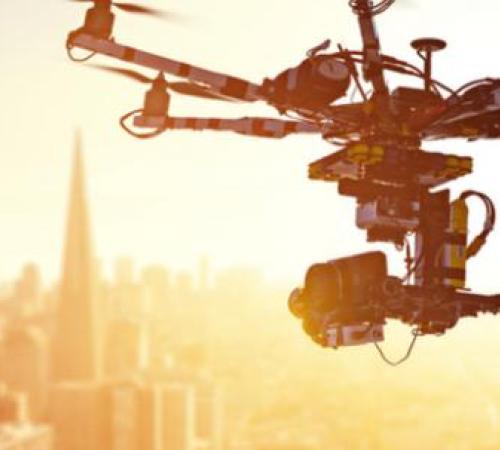 drone flying over cityscape in sunshine